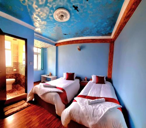 ein Schlafzimmer mit zwei Betten und einer Decke mit einem Fischmotiv in der Unterkunft ColdFeet Home in Kathmandu