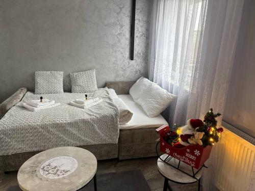 ein kleines Zimmer mit einem Bett und einem Tisch mit Weihnachtsdekoration in der Unterkunft Studio Leszczyńskiego Przemyśl in Przemyśl