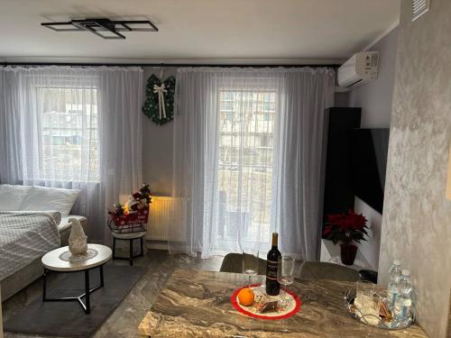 ein Wohnzimmer mit einem Bett und einem Tisch mit einer Flasche Wein in der Unterkunft Studio Leszczyńskiego Przemyśl in Przemyśl
