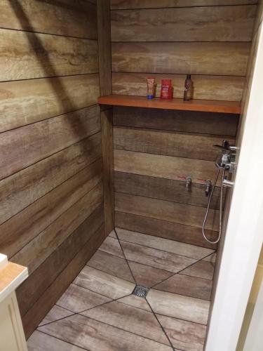 una doccia con pareti rivestite in legno e una mensola di La CATALANE ad Argelès-sur-Mer