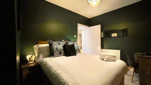 ein Schlafzimmer mit einem weißen Bett mit grünen Wänden in der Unterkunft Cosy 2-Bed Apartment - Nether Edge, Sheffield in Nether Edge