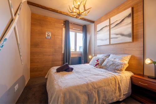 une chambre avec un lit avec un animal en peluche dessus dans l'établissement Le Chalet Savoyard, à Hennebont