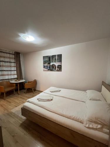 una camera da letto con un letto grande e un tavolo di Focus Home a Miercurea-Ciuc