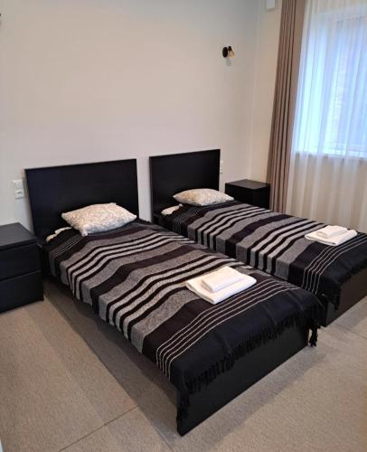two beds sitting next to each other in a room at Jaunāmuiža Apartamenti in Valmiera