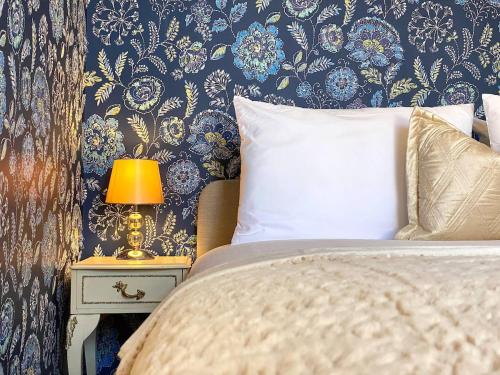 a bedroom with a bed and a lamp on a night stand at 2 Bed Apt Central Truro Ground-Floor Apartment in Kenwyn