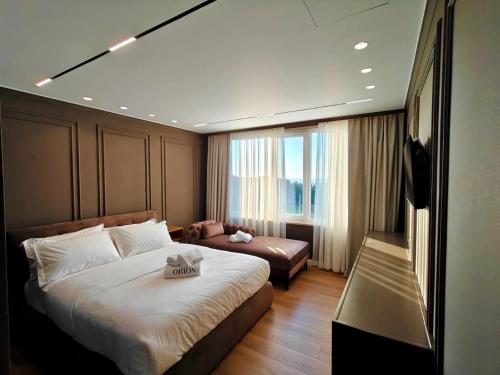a hotel room with a bed and a couch at Orion Palace Boutique Hotel in Durrës