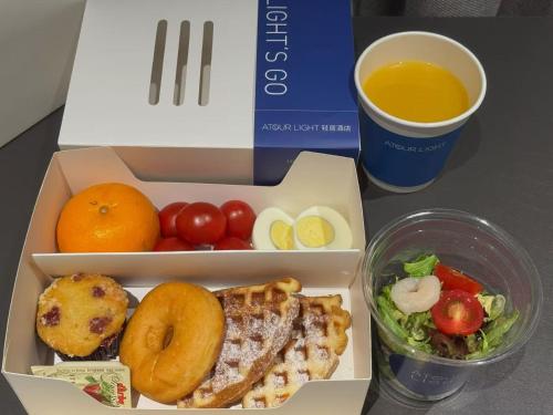 eine Box mit Essen, eine Tasse Kaffee und ein Salat in der Unterkunft Atour Hotel Shanghai Wujiaochang Huangxing Road Subway Station in Shanghai