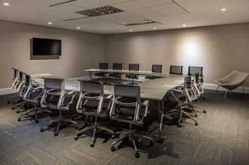 a conference room with a large table and chairs at Novotel RJ Praia de Botafogo in Rio de Janeiro