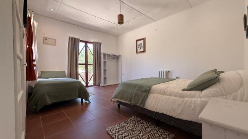 a bedroom with a bed and a table and a window at Hostería Viñas de Uquia in Capla