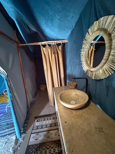 a bathroom with a sink and a mirror in a tent at Pulse Desert Camp in Merzouga