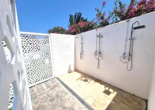 a bathroom with two showers on a white wall at I Venti di Vulcano in Vulcano