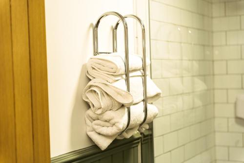 a pile of towels on a towel rack in a bathroom at The Sycamore Inn in Birch Vale