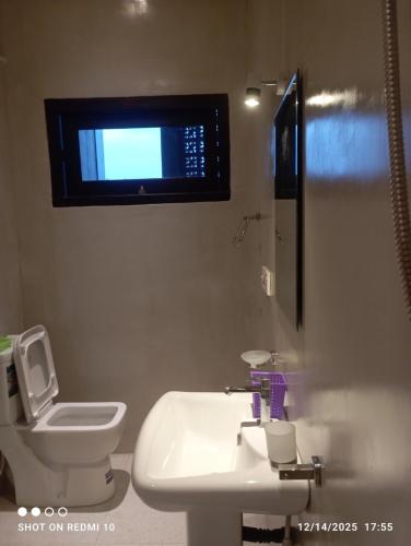 Un baño con lavabo, inodoro y ventana. en Blue Sky Villa 02 Ahangama, en Ahangama