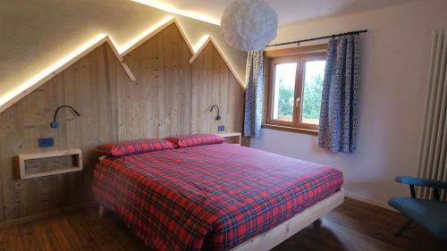 a bedroom with a bed with a checkered blanket at Chalet Peter in Folgaria