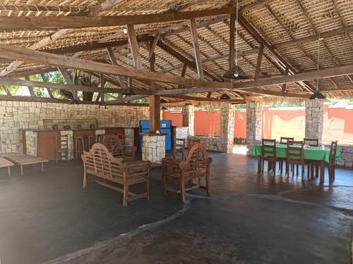 une pièce avec des tables et des chaises dans un bâtiment dans l'établissement Les jardins d'Ambondrona, à Mahajanga