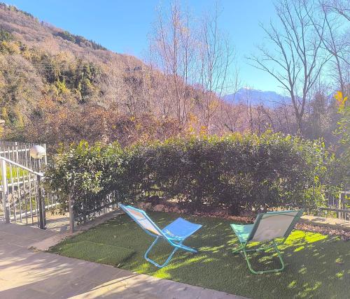 two chairs sitting on the grass next to a fence at Appartamento La Ciliegia in Sovere