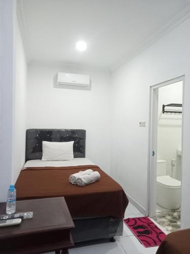 a small bedroom with a bed and a table at Pakemsari Resort Hotel in Pakem