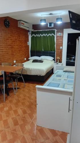 a bedroom with a bed and a table and a dining room at Departamentos tini in La Punta