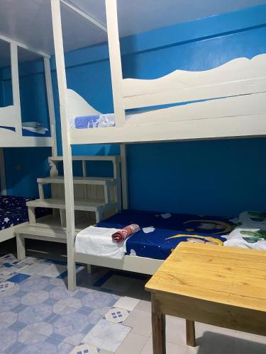 a room with two bunk beds and a table at John Lhea Beach Cottages in Siquijor
