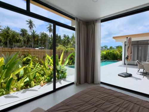 an open living room with sliding glass doors and a swimming pool at White Lotus Villa in Ko Phangan