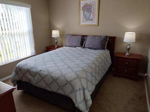 a bedroom with a large bed with two night stands at Florida Villa in Kissimmee