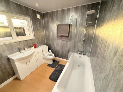 a bathroom with a tub and a sink and a toilet at Cosy Bungalow house in the centre of Sunderland in Sunderland
