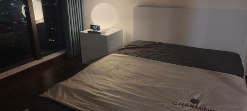 a bedroom with a bed with a night stand and a window at Masteri West Heights 3Br near Korean Town in Phú Thú