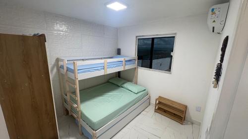 een kleine kamer met 2 stapelbedden en een raam bij Freedom Rooftop - Temos Wallbox 7kW para EV in Garanhuns