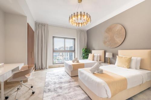 a bedroom with two beds and a desk and a table at Fairmont The Palm Residences I Access to Hotel Facilities in Dubai