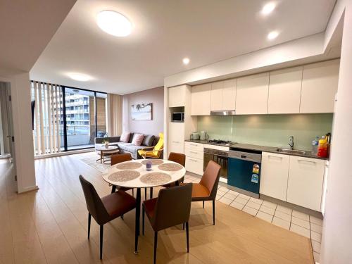 a kitchen and living room with a table and chairs at Wolli Creek Entire 2-Bedroom apartment with 2 bathrooms in Sydney