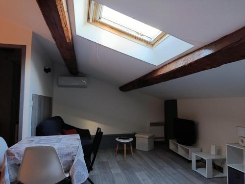Grand studio proche centre في ناربون: غرفة بها سرير ونافذة سقفية