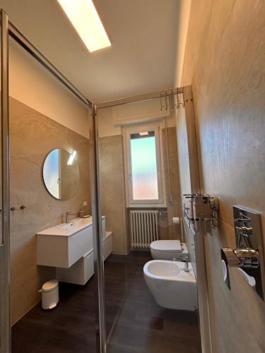 een badkamer met een wastafel, een toilet en een spiegel bij Top Stay Retrò in Costa Volpino