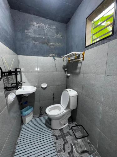 a bathroom with a toilet and a sink at Uchi Siargao in General Luna