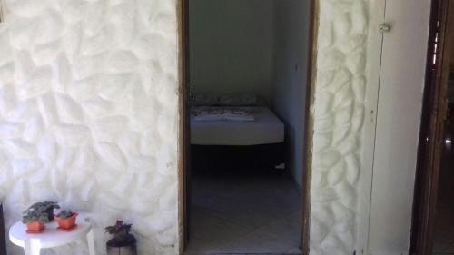 a hallway with a mirror and a bed in a room at Recanto da Kaká in Ilha do Mel