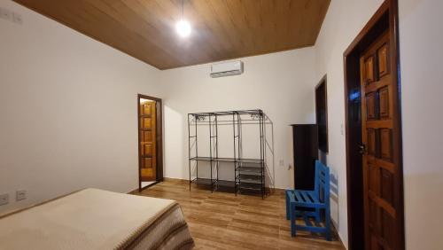 een slaapkamer met een bed en een blauwe stoel bij Flor de Lótus - Vista ao mar in Ilha de Boipeba