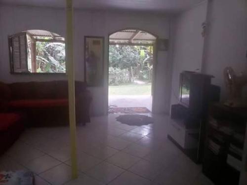 a living room with an open door to a room at Recanto da Kaká in Ilha do Mel