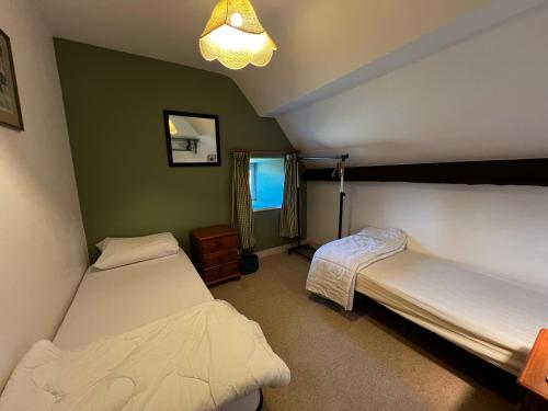 Un dormitorio con dos camas y una lámpara. en Gîtes du Gohic - L'Ecurie, en Quistinic