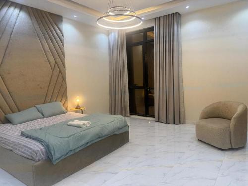 a bedroom with a bed and a chair at Faj Residence home stay in Ajman 