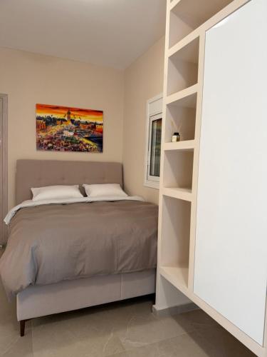 Un dormitorio con una cama y una estantería. en LIV Aspropyrgos, en Asprópirgos