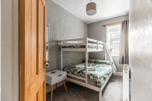 En eller flere senge i et værelse på Haworth Stone Cottage with Log Burner and Valley Views