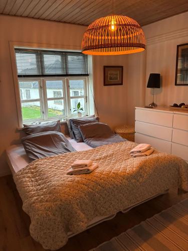 a bedroom with a large bed and a chandelier at Lejlighed ved havet in Lønstrup