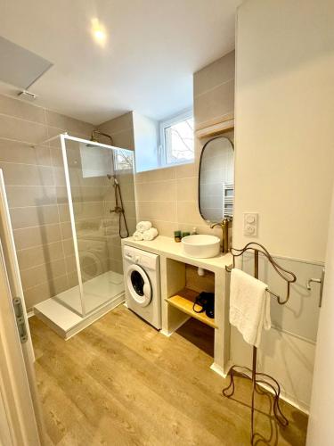 a bathroom with a washing machine and a sink at L écrin secret de Foix in Foix