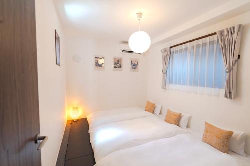 a bedroom with two beds and a window at sunshin dream in Osaka