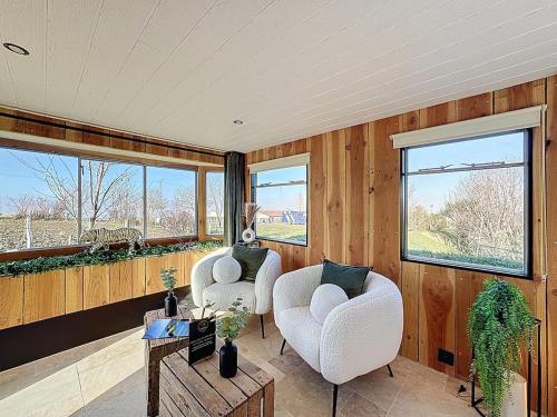 a room with two chairs and a table and windows at Unique Cabane 4 spa Centre Équestre & Snack in Vic-le-Comte