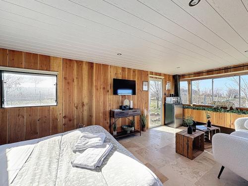 a bedroom with wooden walls and a bed and a television at Unique Cabane 4 spa Centre Équestre & Snack in Vic-le-Comte