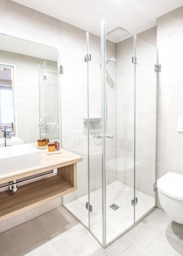 a bathroom with a glass shower and a toilet at Burghotel Lingen in Lingen