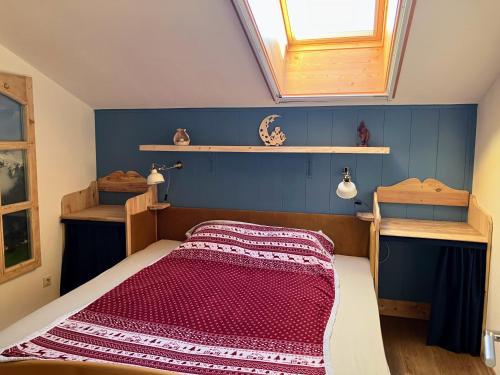 a bedroom with a bed with a window and shelves at Dachstein Stüberl in Bad Aussee