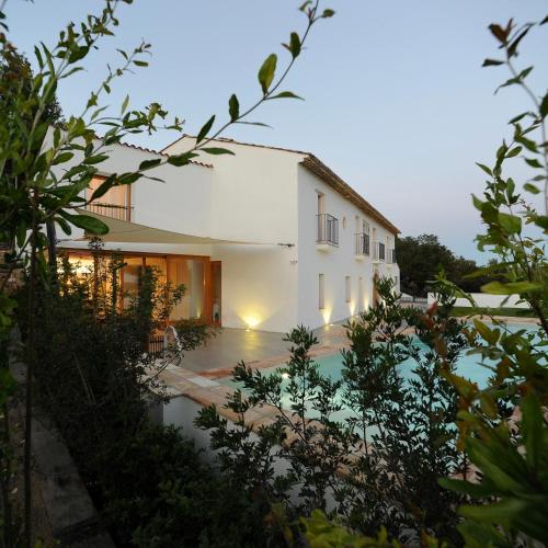 a white house with a pool in front of it at Villa Masia Capdet in Sant Pere de Ribes