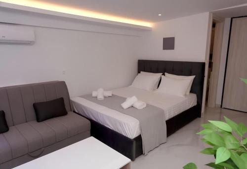 a bedroom with a bed and a couch at IFI Apartments in Paralia Katerinis