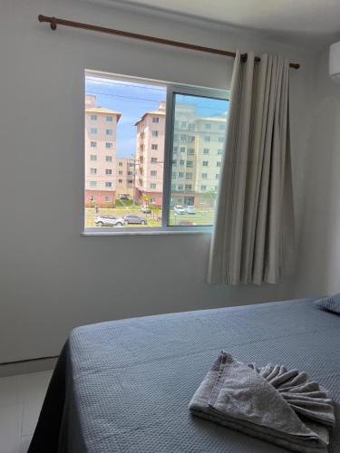 a bedroom with a bed and a large window at VOG Torres do Sul Litoral Ilhéus in Ilhéus